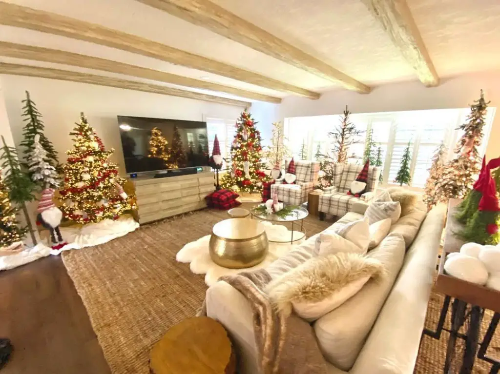 Traditional living room with Christmas tree, green curtains, crown molding, and classic decor.