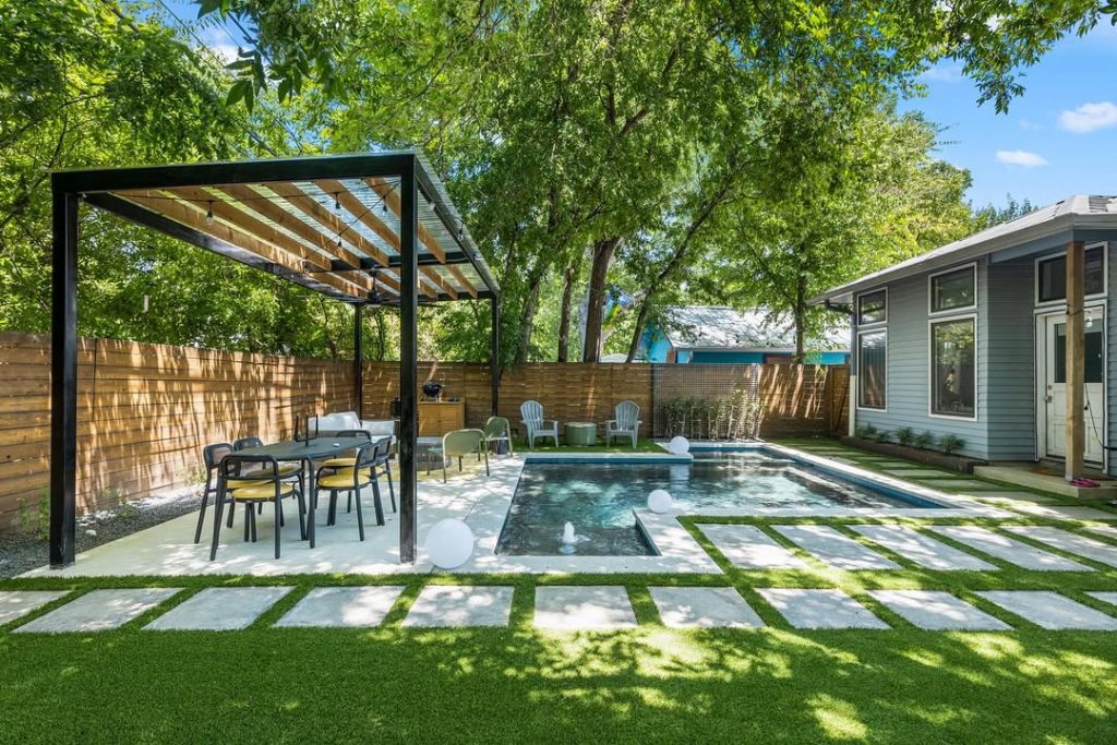 Modern pool with geometric paving and pergola dining area