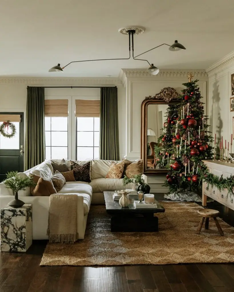 Traditional living room with Christmas tree, green curtains, crown molding, and classic decor.