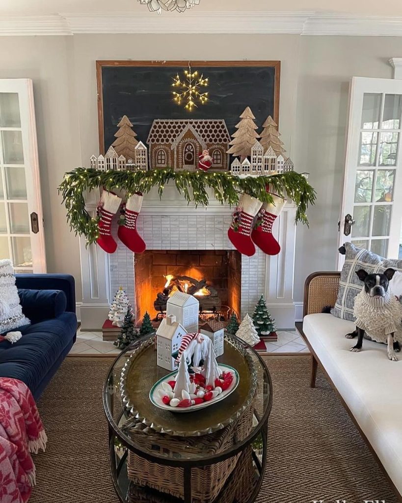 Christmas fireplace with gingerbread village display stockings and holiday decorations