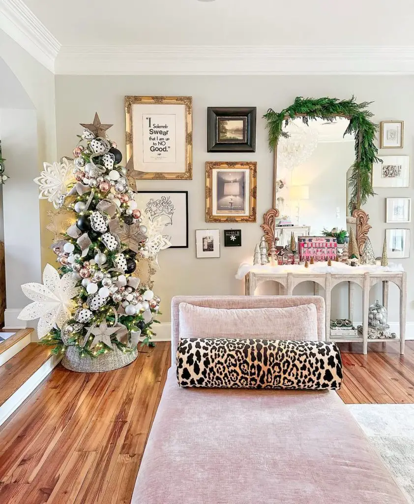 Stylish living room with gallery wall, polka dot Christmas tree, and leopard print ottoman.