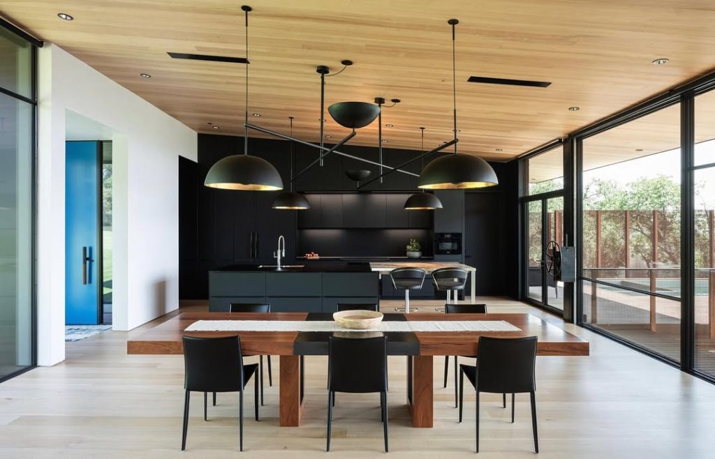  Modern black kitchen with wood dining table and large windows