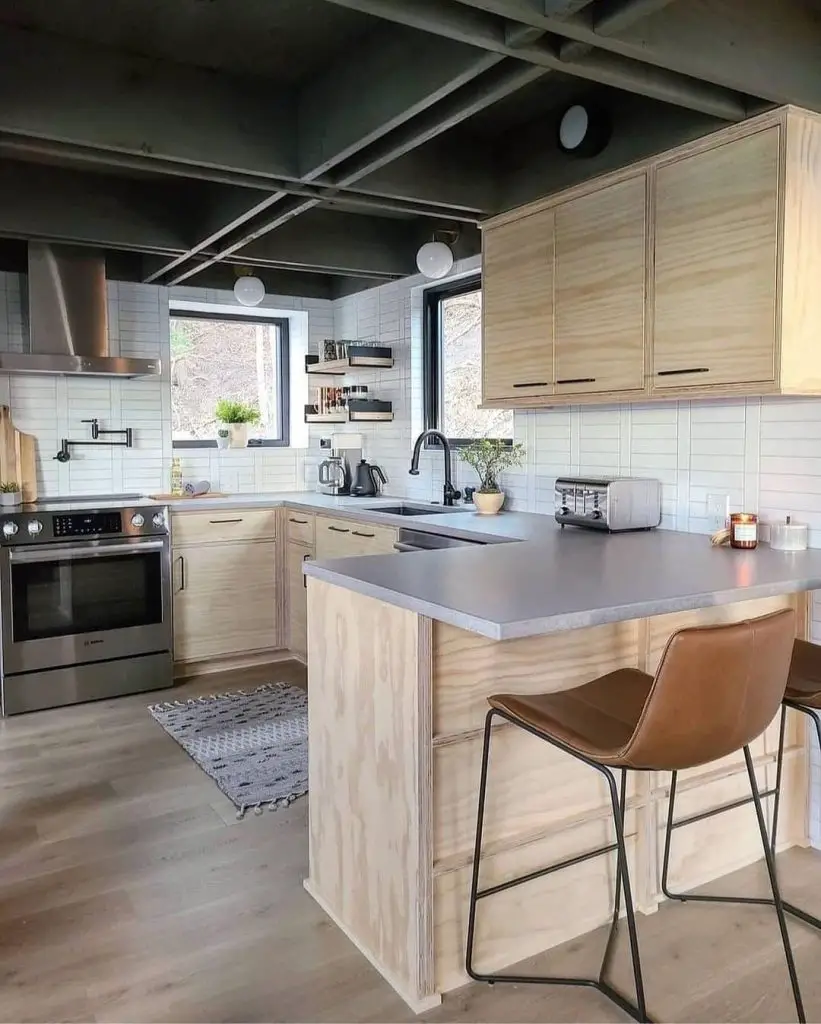 Modern kitchen with exposed beams, wood cabinets, concrete counters, leather stool