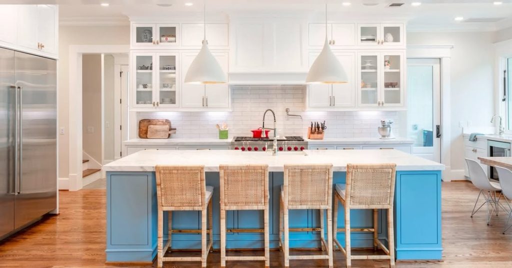 White kitchen cabinets with blue island and woven stools