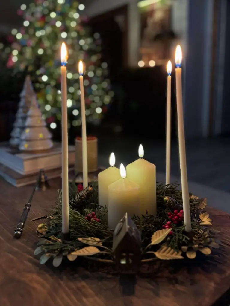 Christmas table centerpiece with multiple candles and greenery