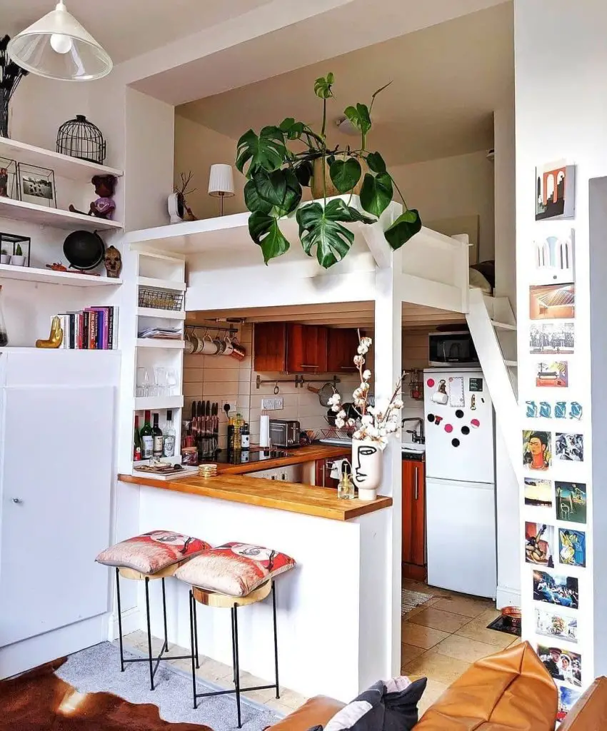Compact loft kitchen with vertical storage, peninsula counter, built-in shelving