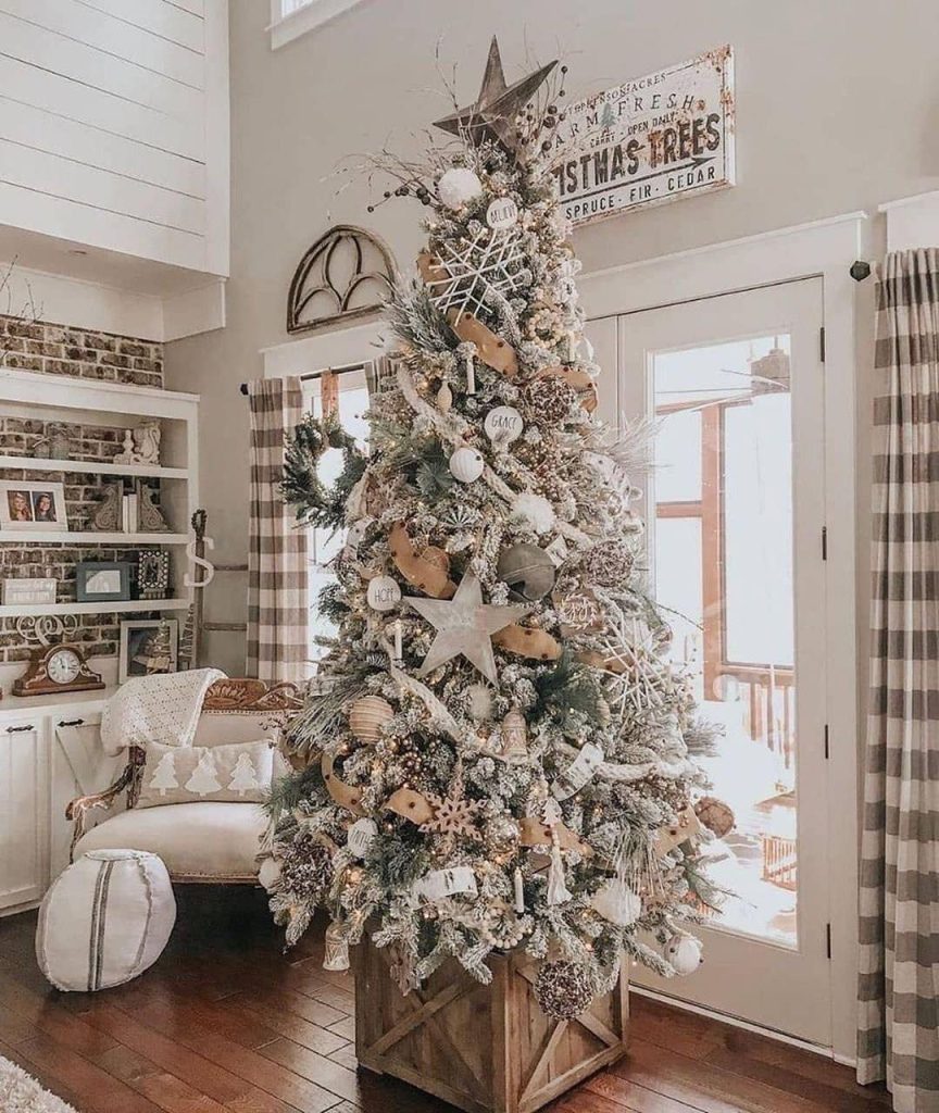 Elegant farmhouse living room with flocked Christmas tree and neutral decorations