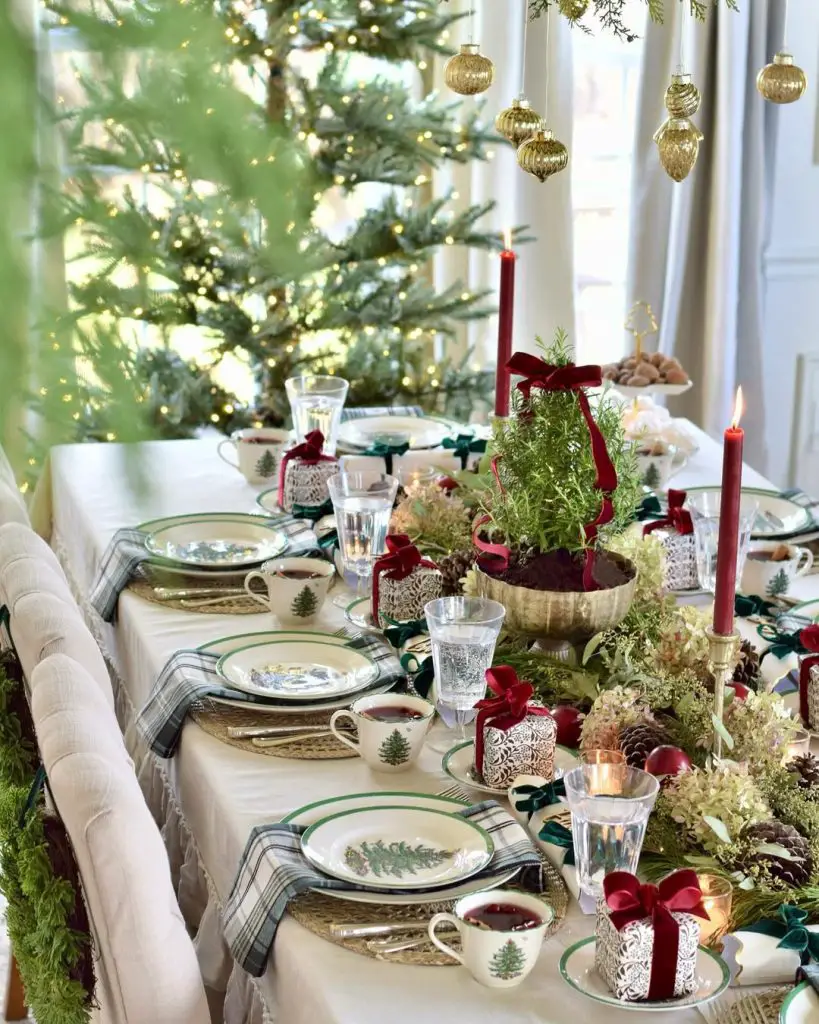 Christmas dining table by window with hanging ornaments and lit tree