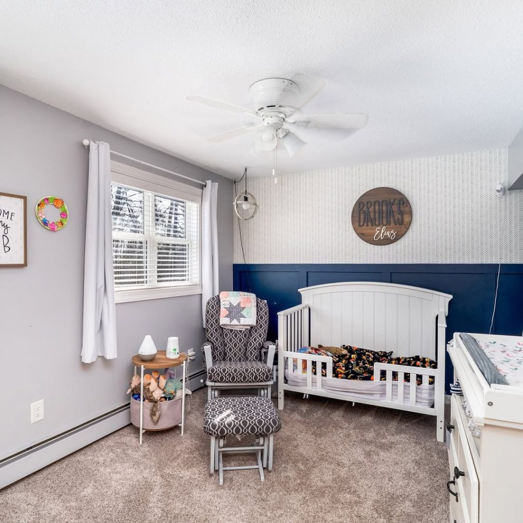 Modern nursery featuring herringbone wallpaper and navy blue accents