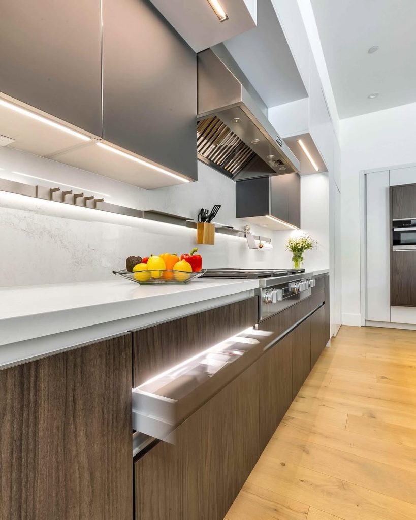 Linear kitchen design with wood cabinets and under cabinet lighting