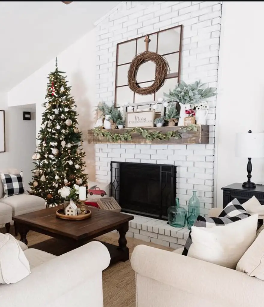 Modern living room with white fireplace, minimal Christmas tree, and clean holiday styling.