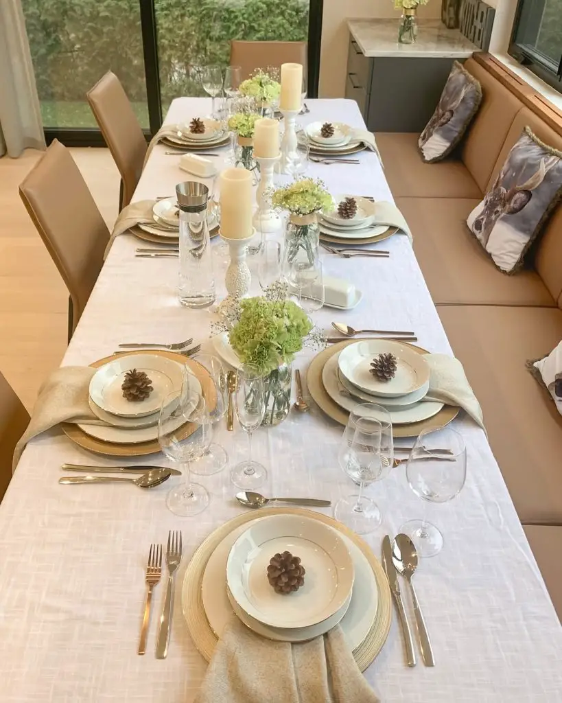 Modern holiday table with hydrangeas, white candles, and golden charger plates