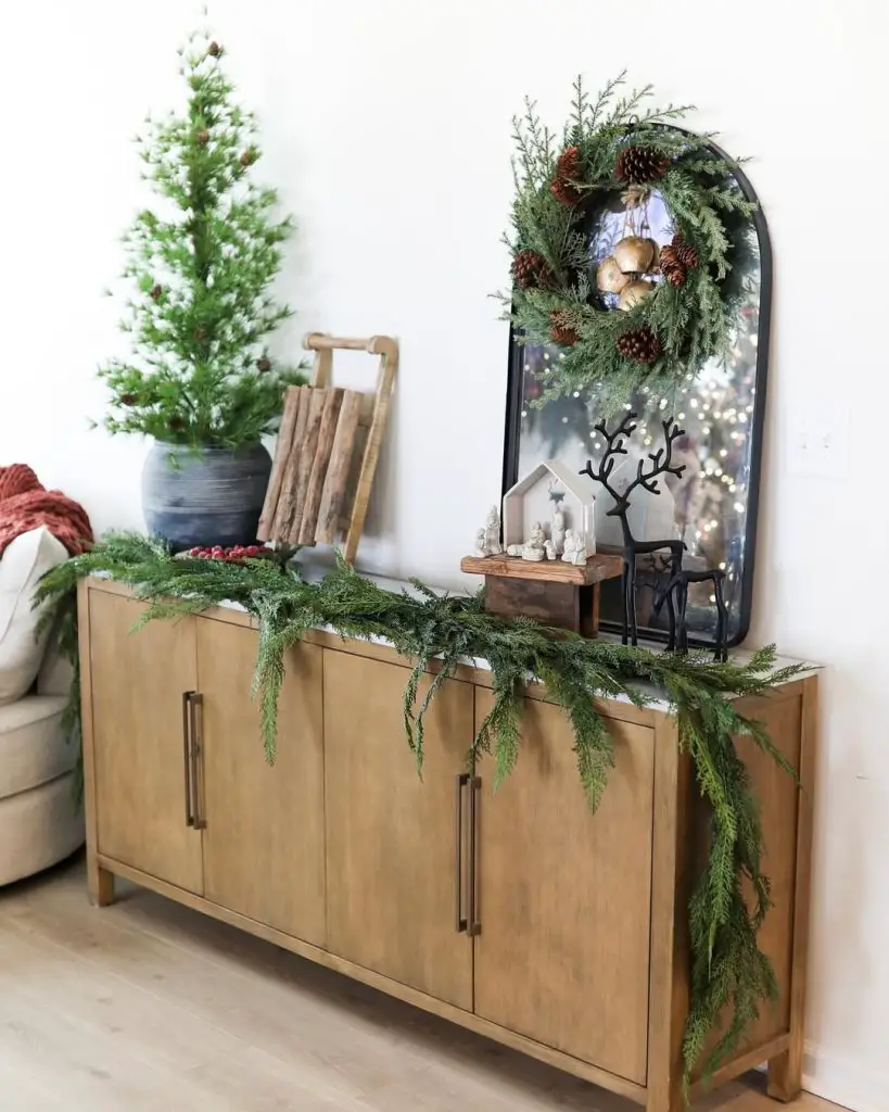 Wooden sideboard decorated with Christmas greenery and rustic elements