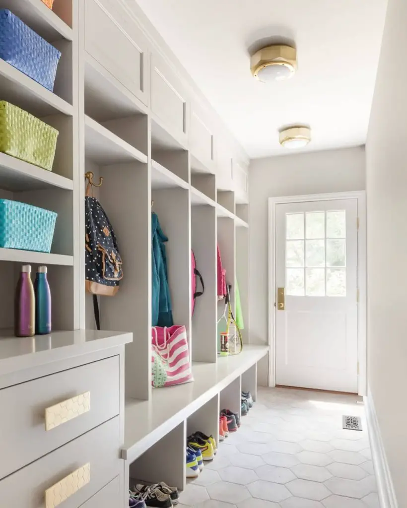 Organized mudroom with hexagonal tiles, colorful bins, and individual cubbies