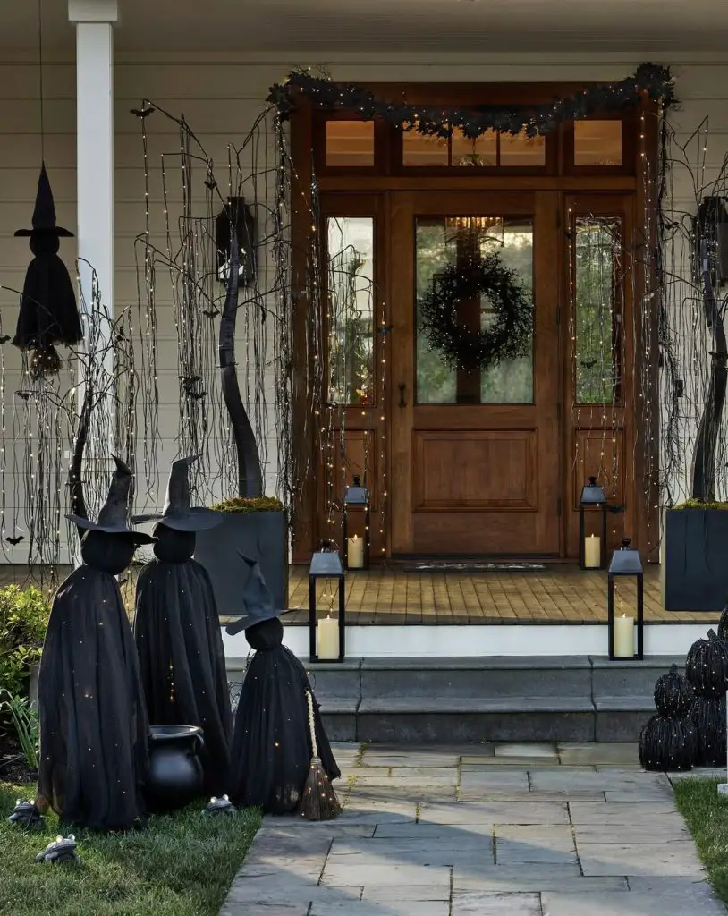 Covered porch with witch figures fairy lights creating magical entrance