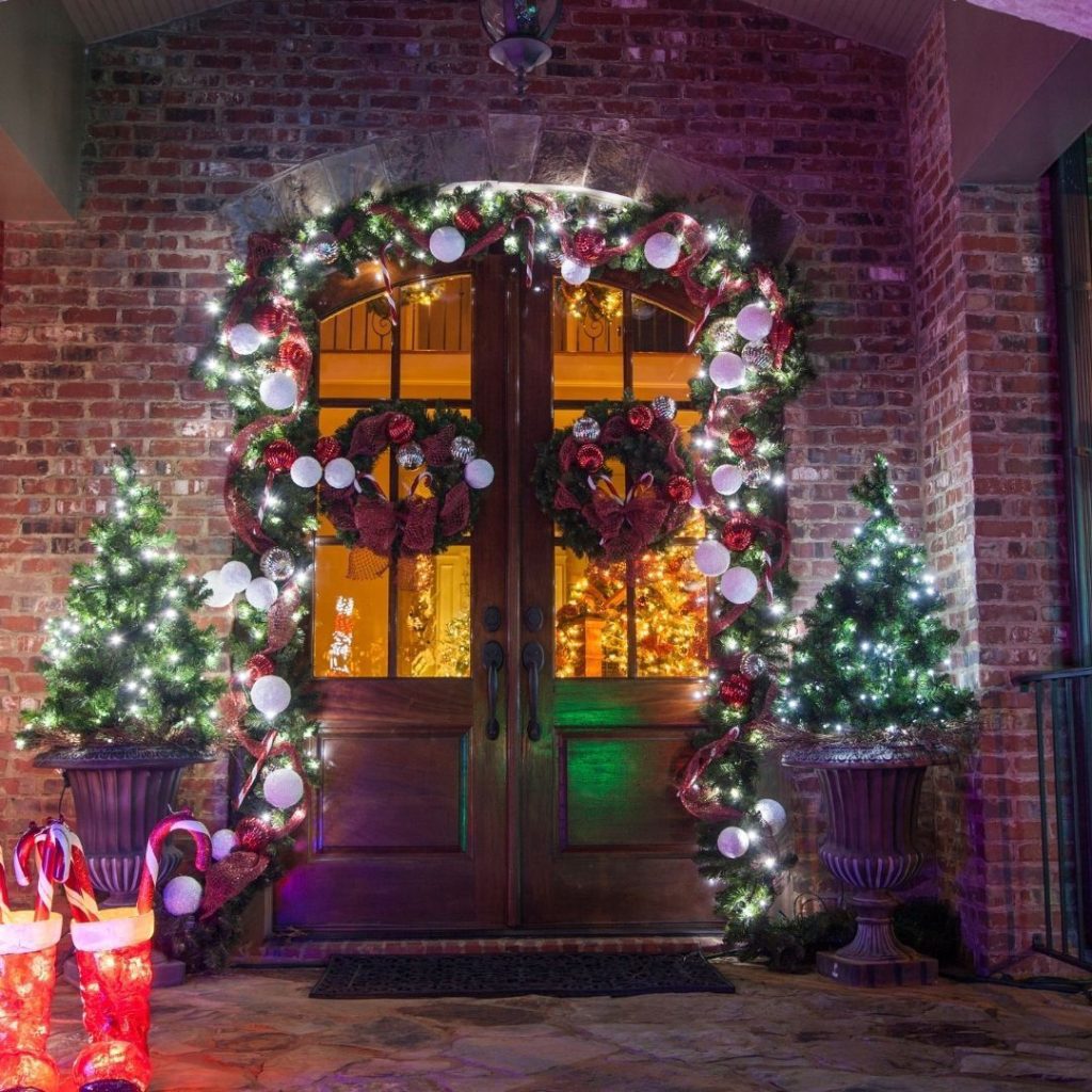 Stone archway entrance decorated with Christmas garland and coordinated wreaths