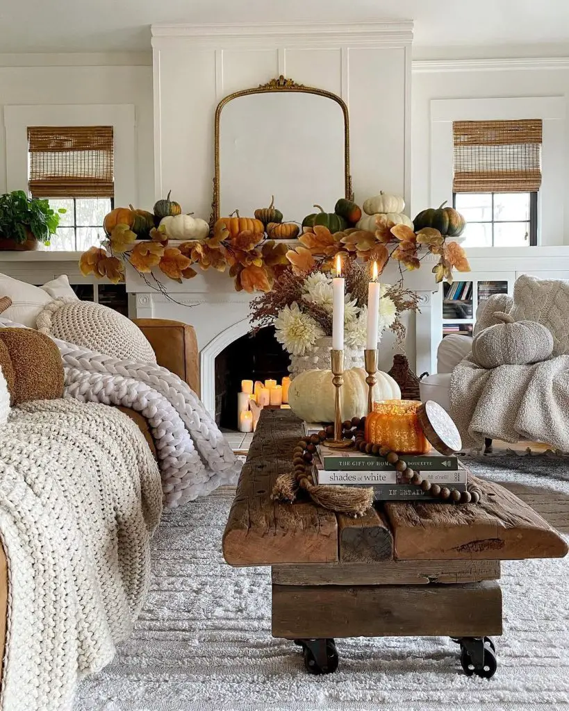 White fireplace mantel with pumpkin garland and candlelight