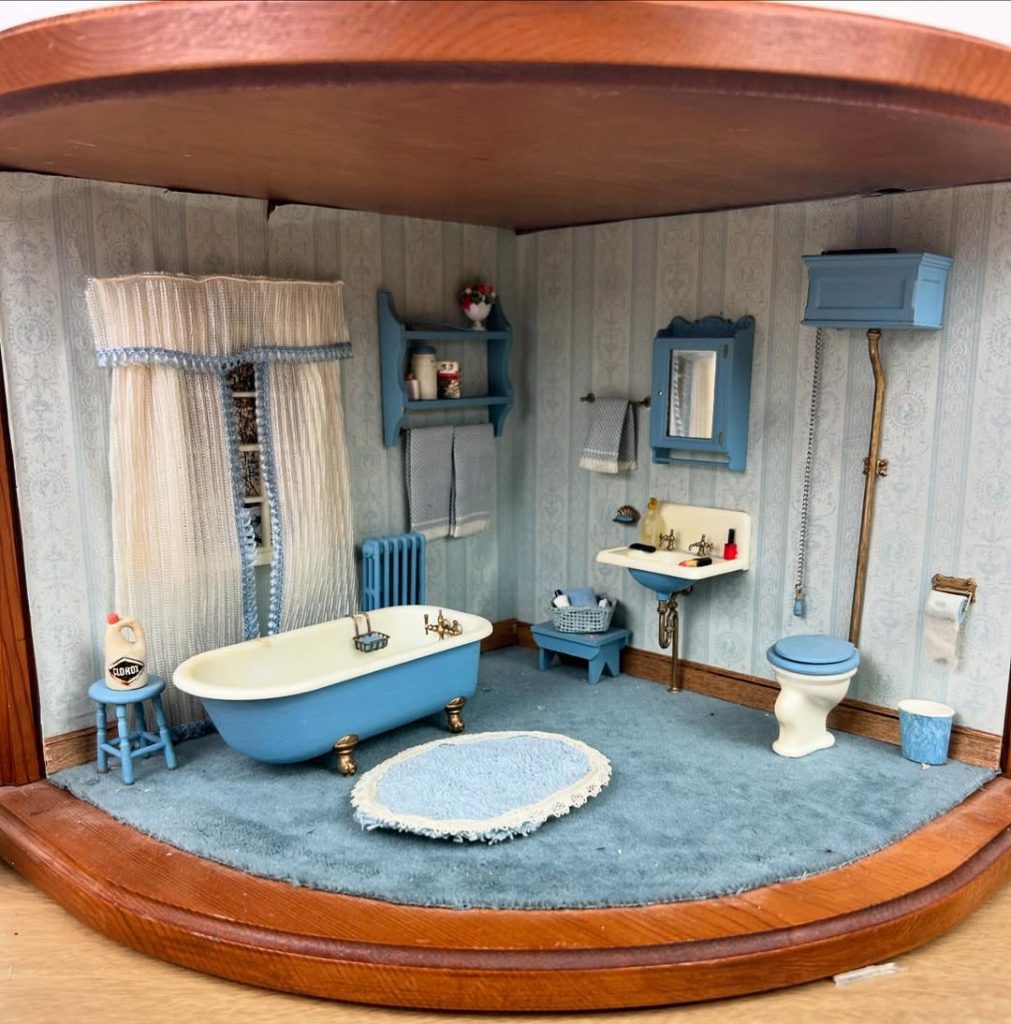 Miniature blue dollhouse bathroom with tiny clawfoot tub