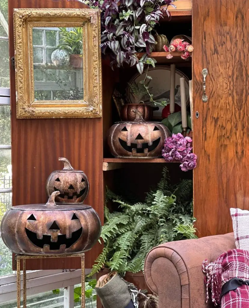 Rustic cabinet with copper jack-o-lanterns and purple flowers