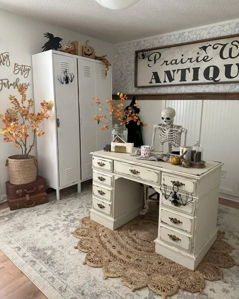 White vintage desk with skeleton Halloween decor and autumn plants