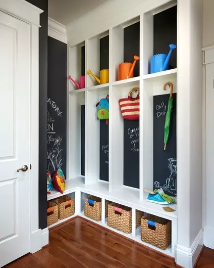 White mudroom with chalkboard walls and colorful storage bins