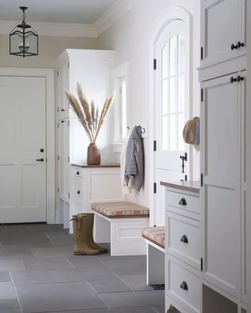 Elegant white mudroom with built-in storage and pendant lighting