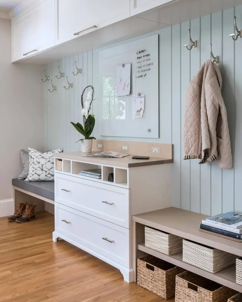 Blue-walled mudroom with white desk and bulletin board organization