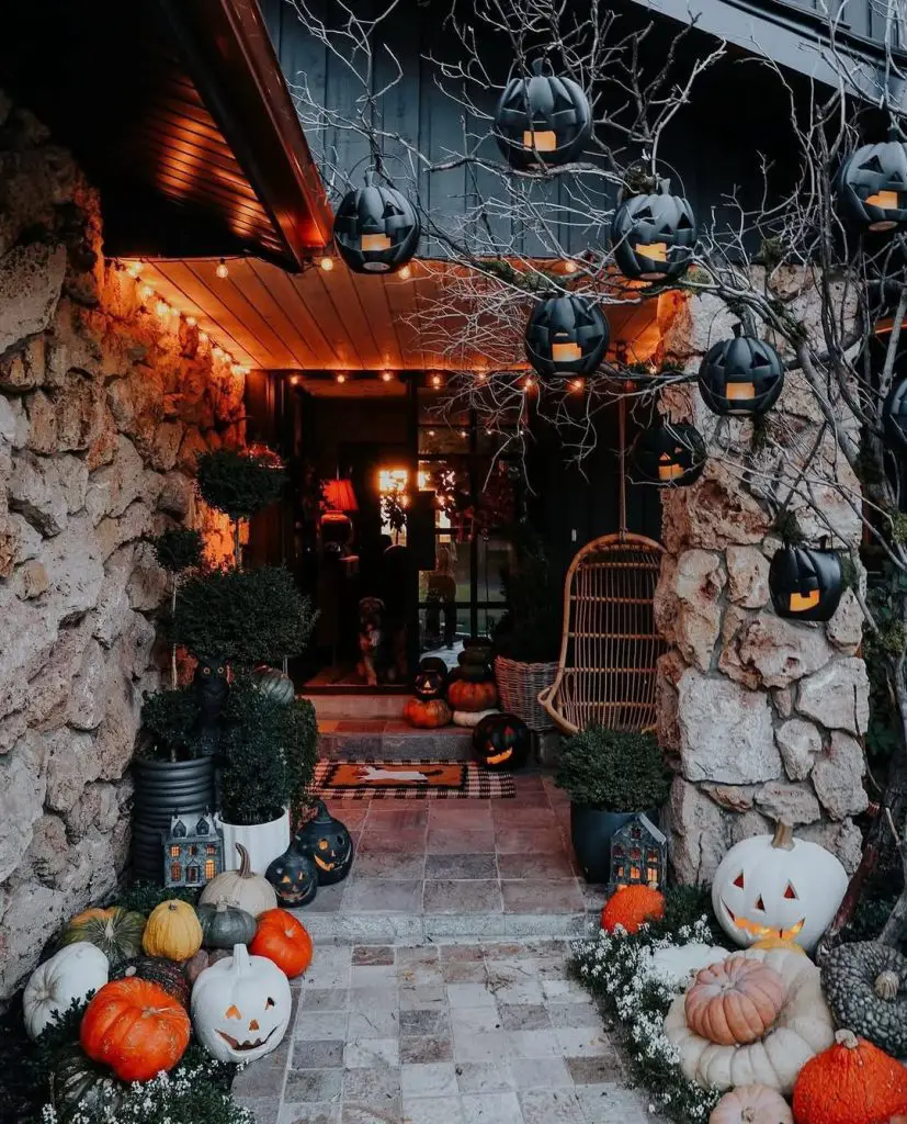 Stone cottage entrance with hanging pumpkin lights autumn decorations