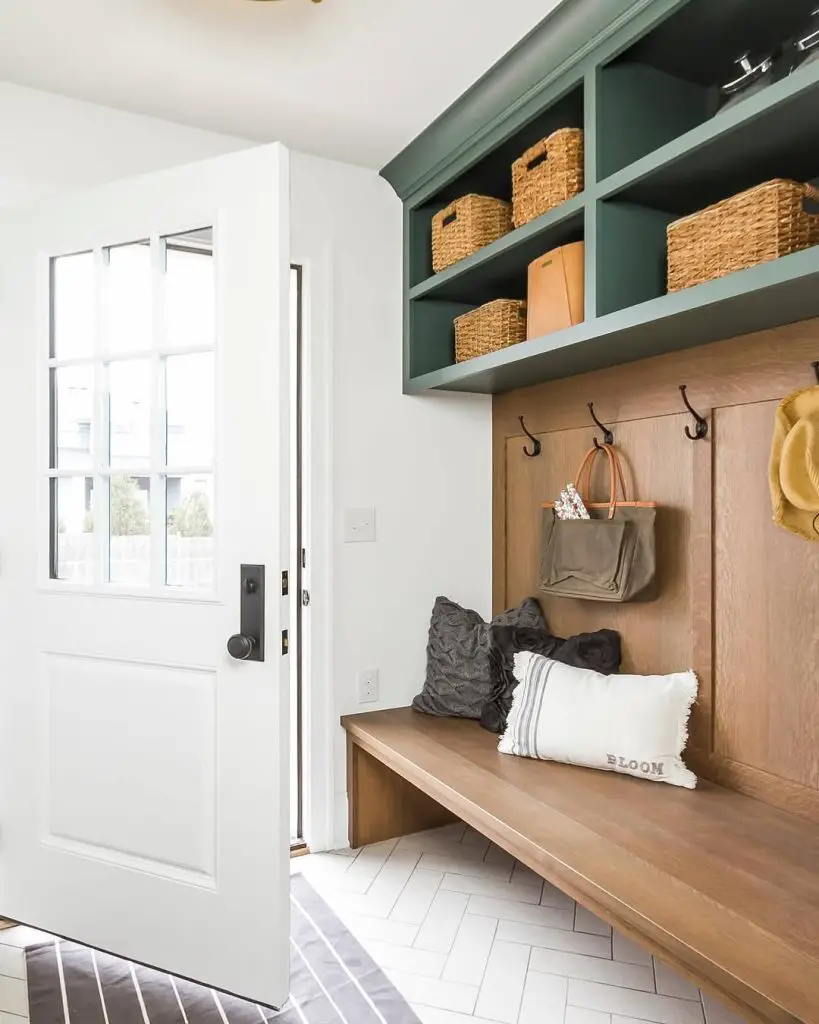 Modern mudroom with green cabinets and herringbone tile floors