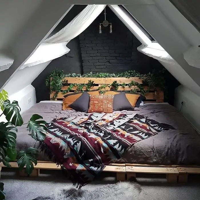 Attic bedroom with dark walls and colorful textiles