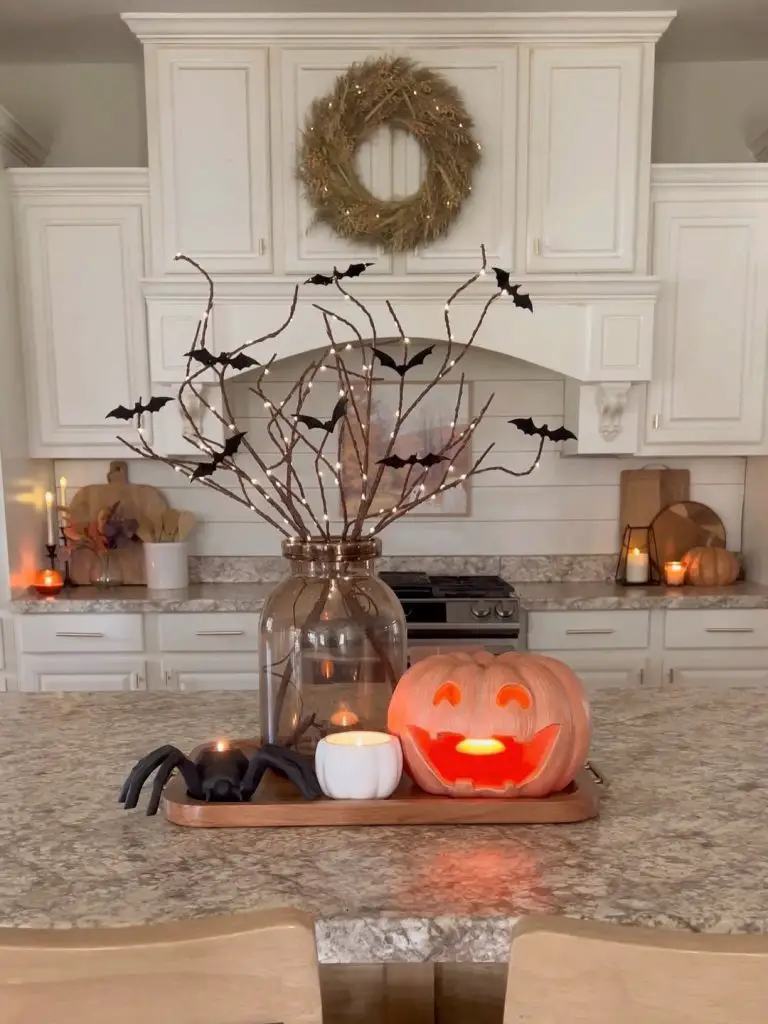 Kitchen island with carved pumpkin bat branches and candlelight