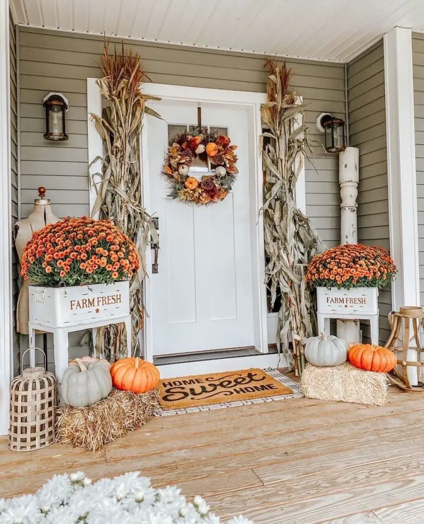 Front porch decorated with mums corn stalks hay bales autumn pumpkins