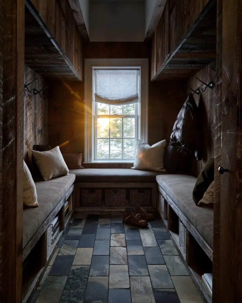 Wood-paneled mountain mudroom with stone floors and cushioned seating
