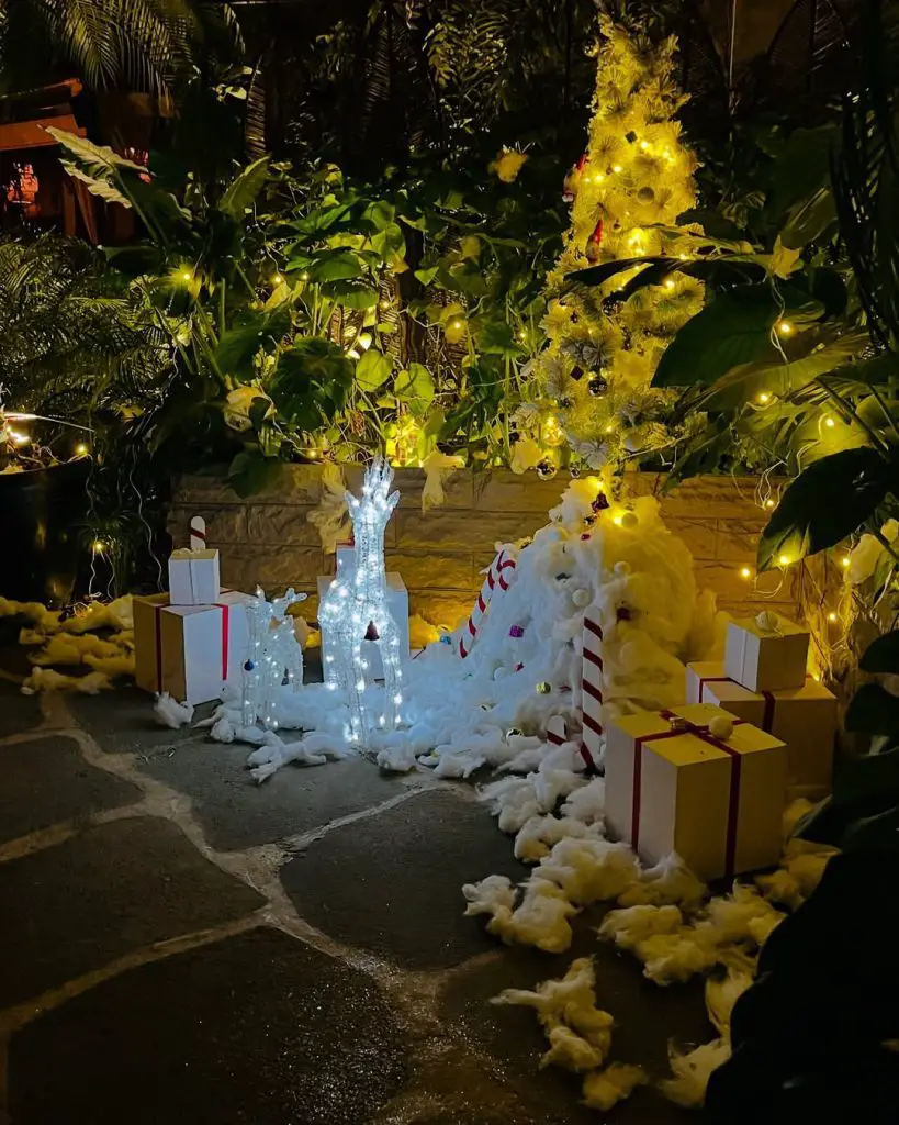 Modern white arch entrance with wreaths evergreen trees