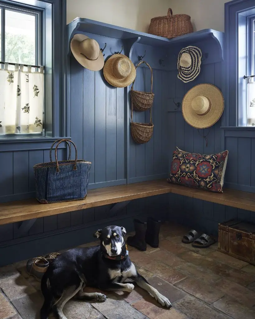 Blue corner mudroom with vintage hat display and beadboard
