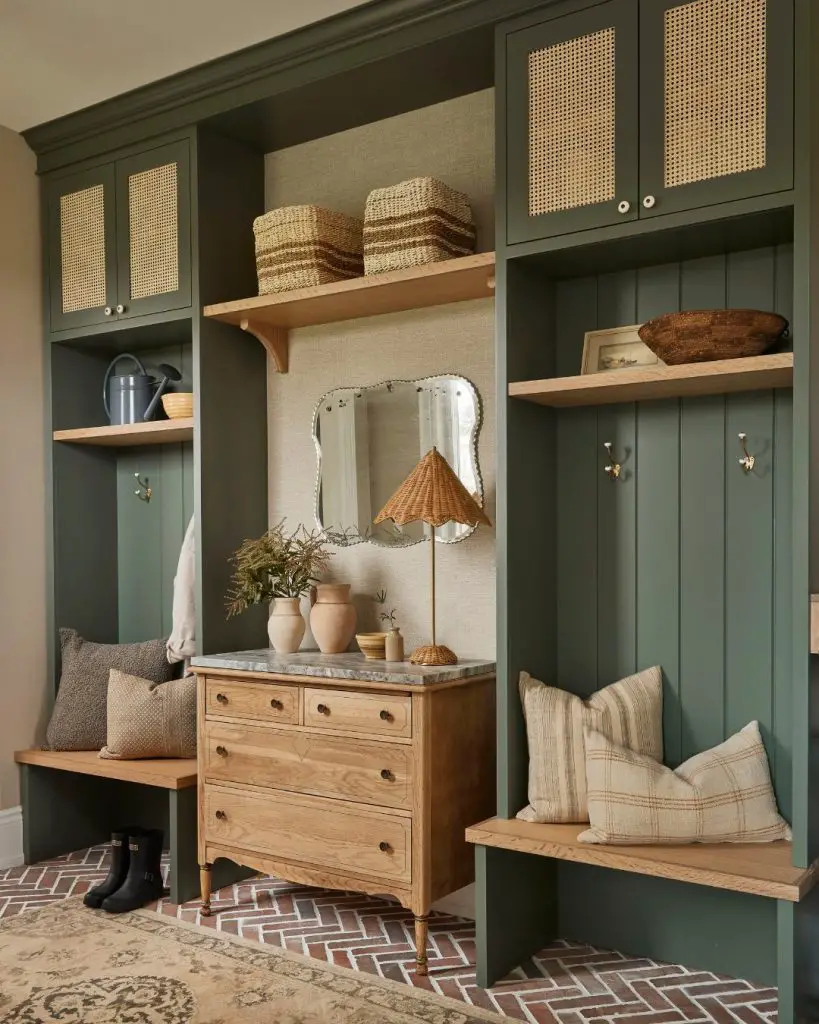 Green mudroom with cane cabinet doors and brick flooring