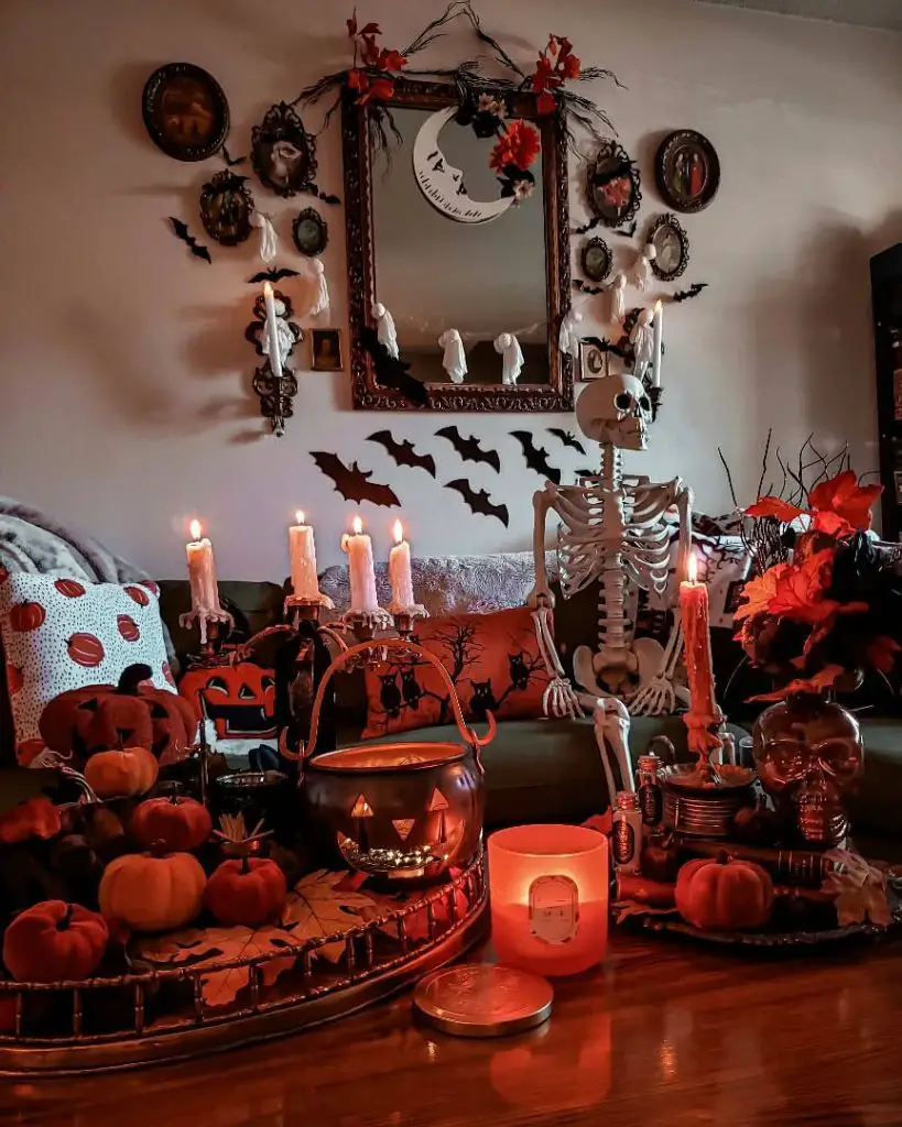  Indoor Halloween display with skeleton candles pumpkins vintage frames