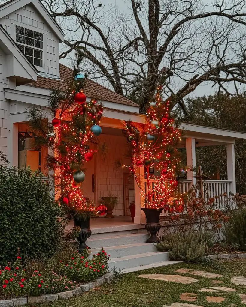 House front yard decorated with Christmas lights on trees and ornaments