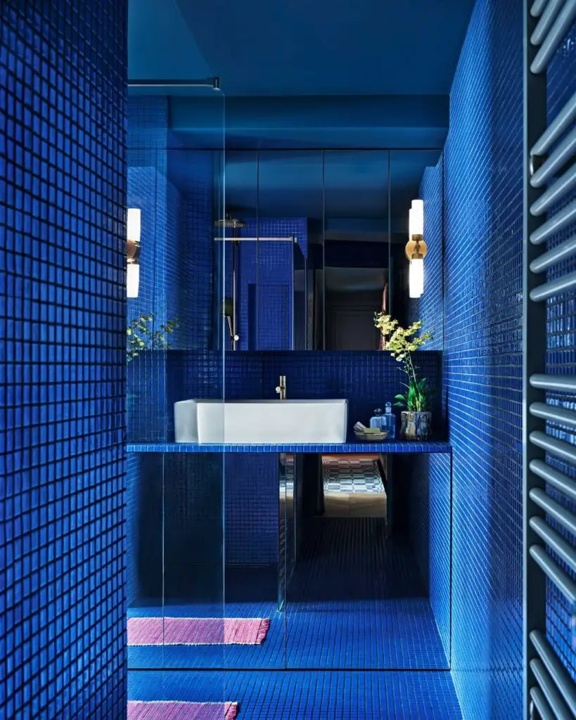 Deep blue tiled bathroom with glass shower and floating vanity