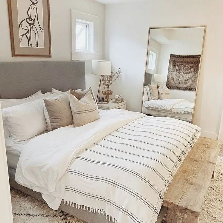 Minimal neutral bedroom with large mirror and textures