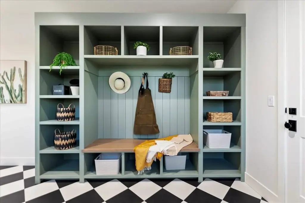 Sage green mudroom with built-in hutch, checkerboard floor, and storage bench