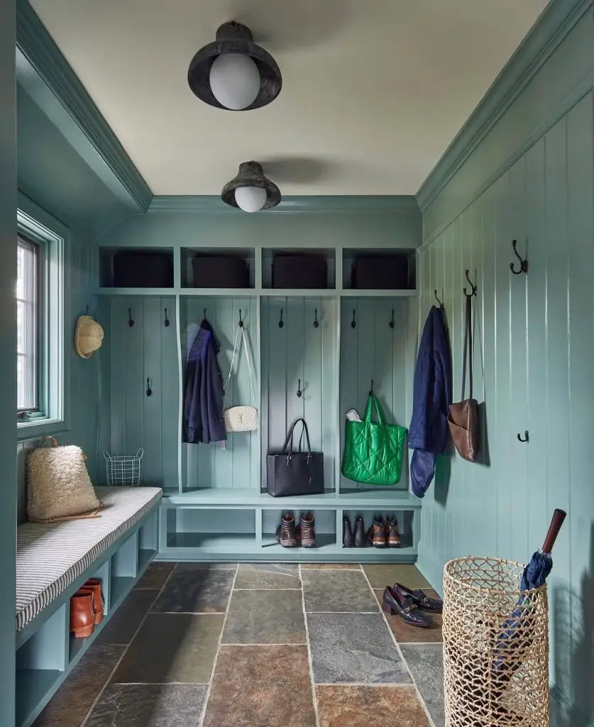 Green mudroom with individual lockers, stone flooring, and bench seating
