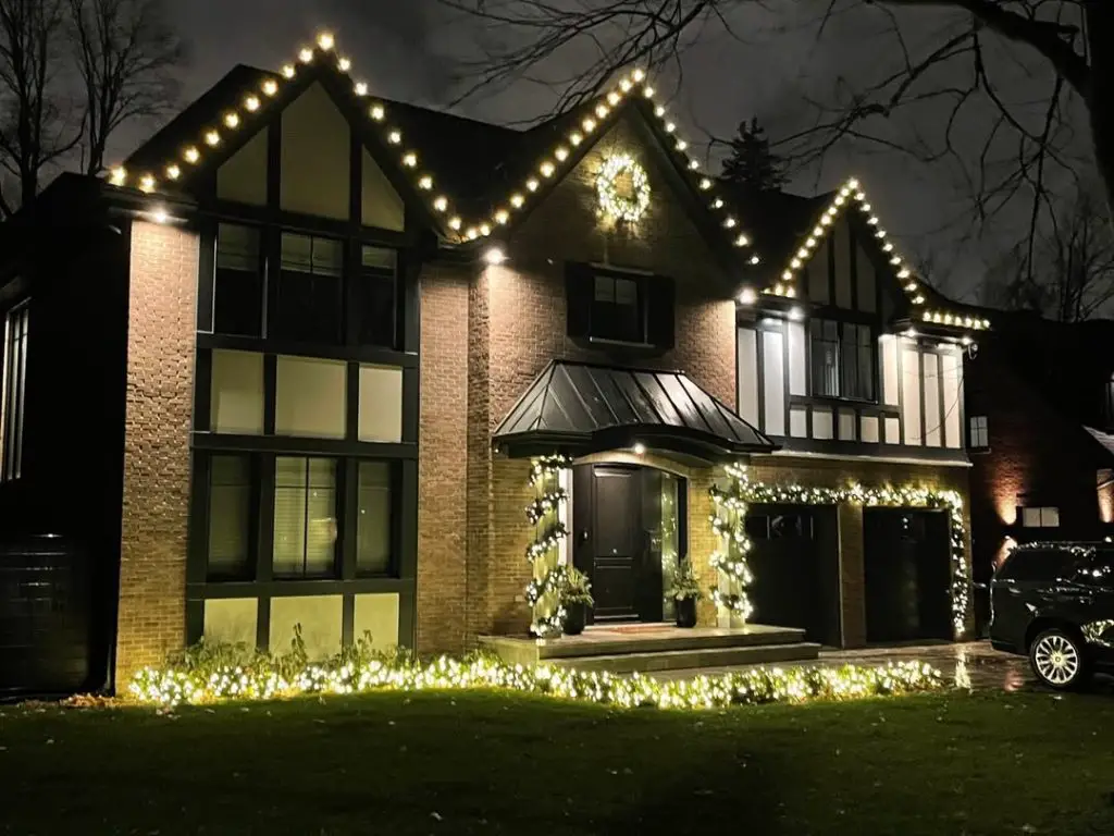 Modern house with Christmas lights outlining roofline and architectural features
