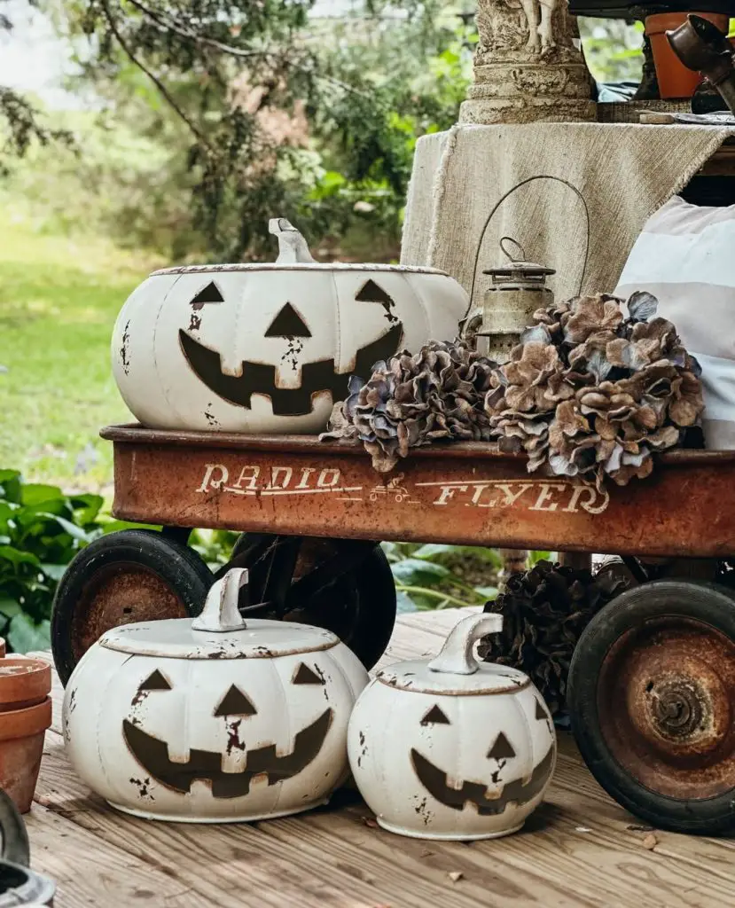 Vintage red wagon filled with white ceramic pumpkins dried flowers