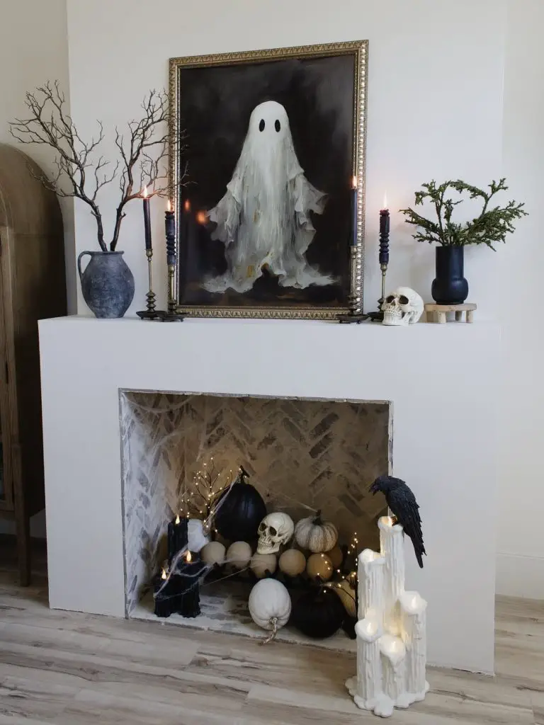 White fireplace mantel with large ghost portrait and elegant Halloween decorations