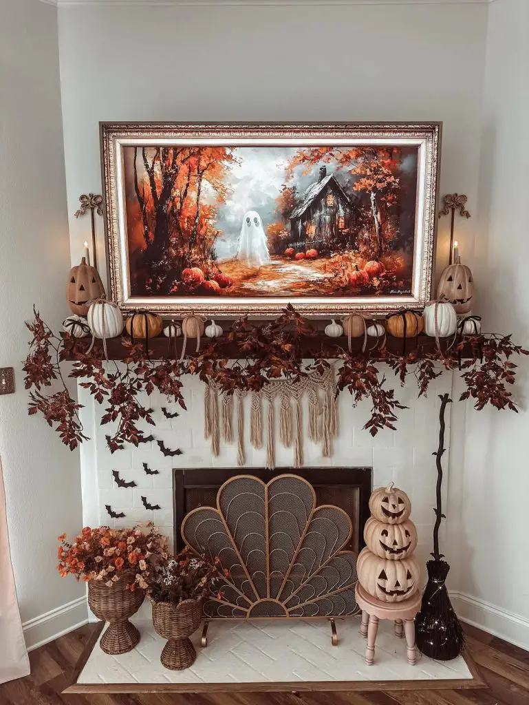 Fireplace mantel featuring Halloween painting with autumn garland and decorative pumpkins