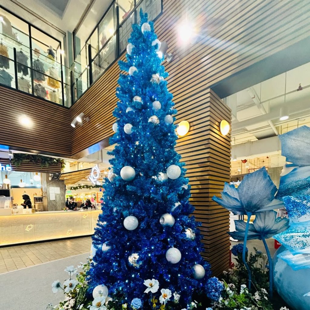 Bright blue Christmas tree in modern shopping mall
