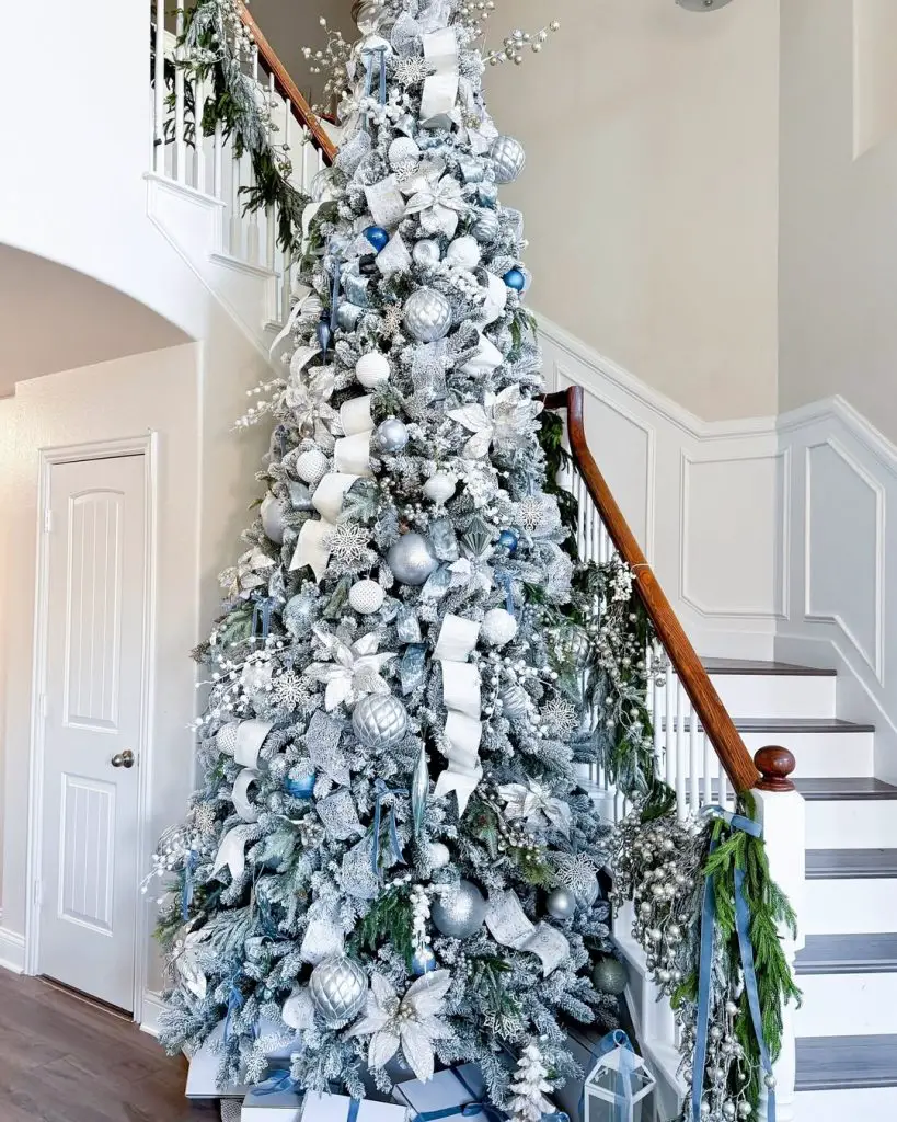 Large white Christmas tree decorating tall stairway entrance