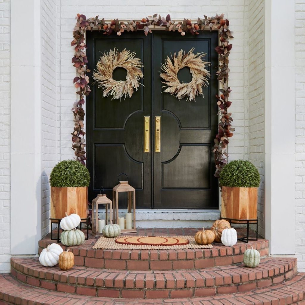 Double doors with wheat wreaths and autumn garland