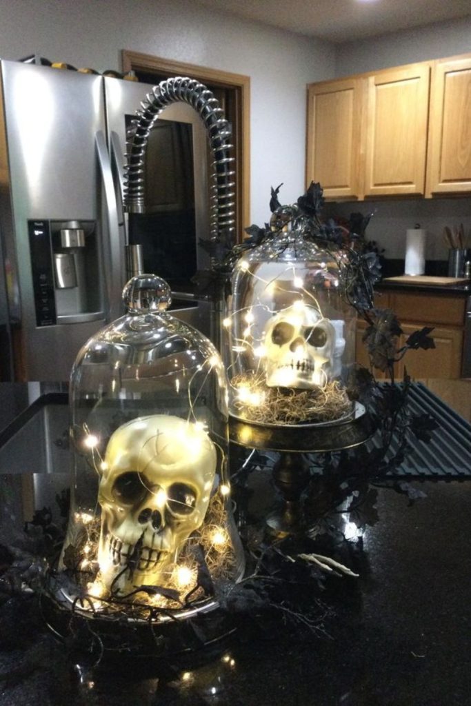 Skull terrarium filled with glowing candles.